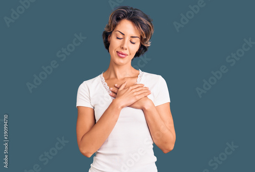 Young beautiful woman wearing casual clothes smiling with hands on chest with closed eyes and grateful gesture on face. health concept.