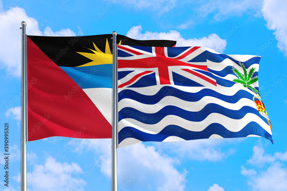 British Indian Ocean Territory and Antigua and Barbuda national flag waving in the windy deep blue sky. Diplomacy and international relations concept. British Indian Ocean Territory and Antigua and Barbuda national flag waving in the windy deep blue sky. Diplomacy and international relations concept.