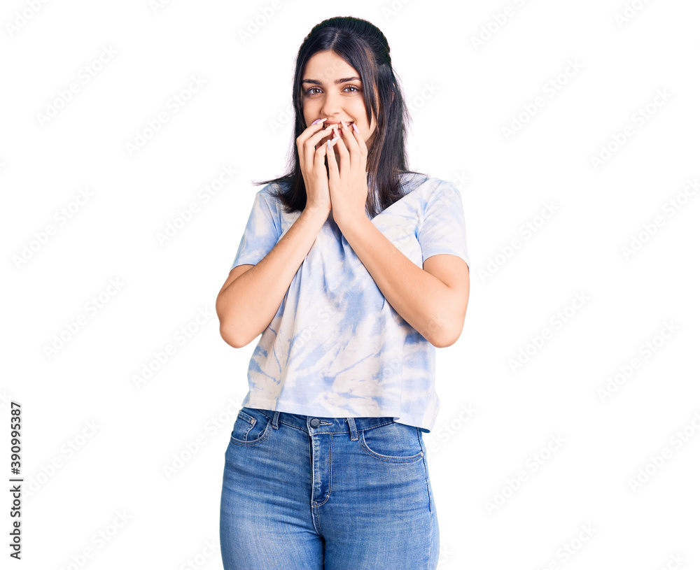 Young beautiful girl wearing casual t shirt laughing and embarrassed giggle covering mouth with hands, gossip and scandal concept Young beautiful girl wearing casual t shirt laughing and embarrassed giggle covering mouth with hands, gossip and scandal concept