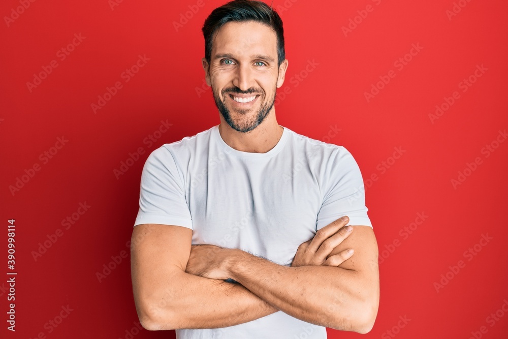 Young handsome man wearing casual white tshirt happy face smiling with crossed arms looking at the camera. positive person. Young handsome man wearing casual white tshirt happy face smiling with crossed arms looking at the camera. positive person.