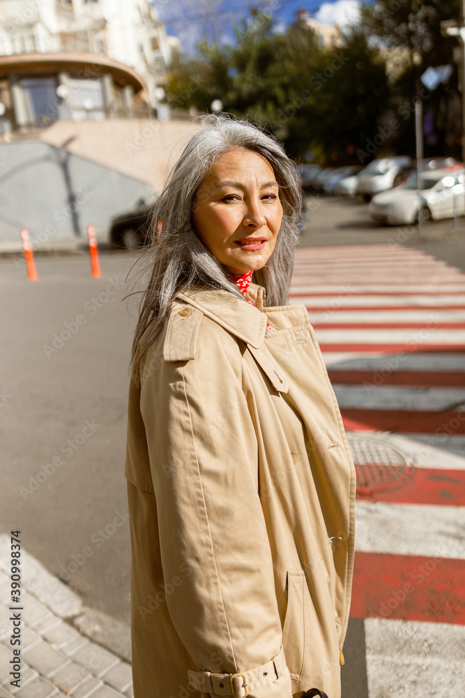 Fototapeta premium Mature pale hair stylish woman lifestyle portrait outdoors in city