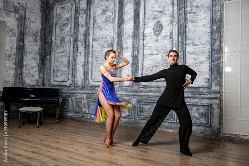 beautiful couple with dance costumes dancing latin dances in the hall © константин константи