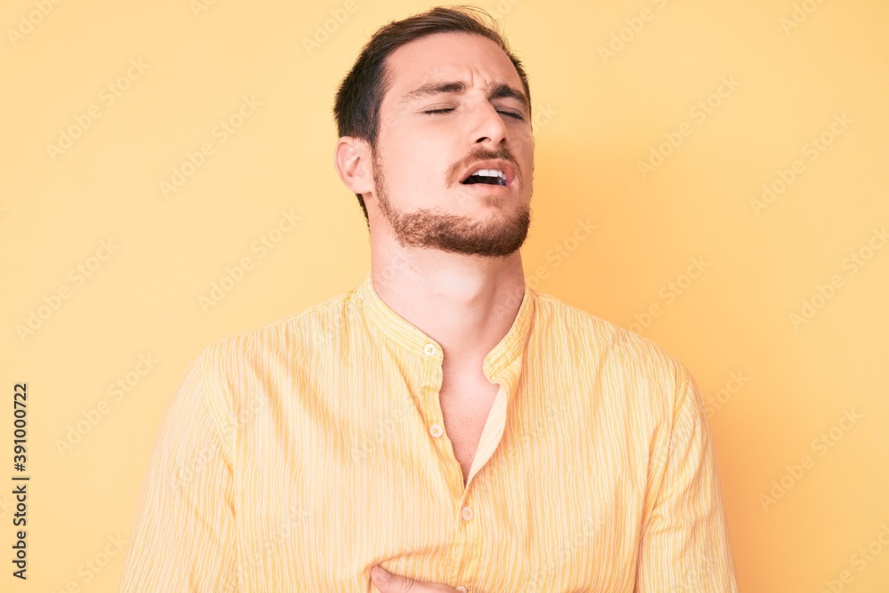 Young handsome man wearing casual clothes with hand on stomach because nausea, painful disease feeling unwell. ache concept. Young handsome man wearing casual clothes with hand on stomach because nausea, painful disease feeling unwell. ache concept.