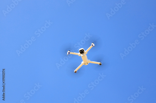 Drone blanc qui vole de ans le ciel bleu