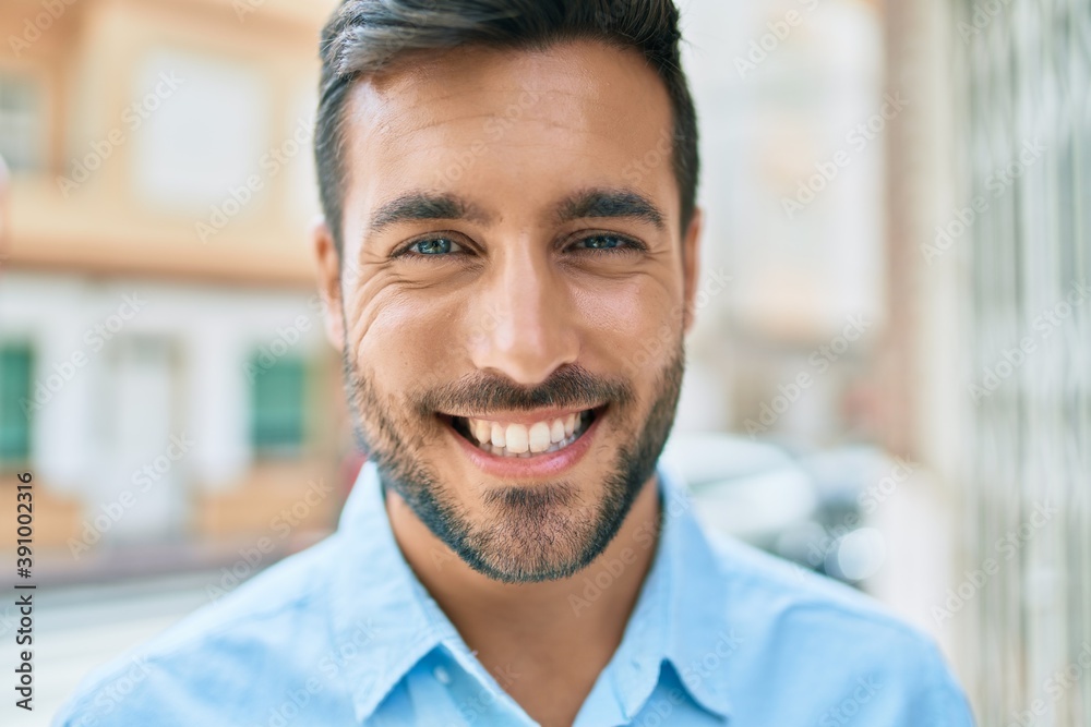 Young hispanic man smiling happy standing at street of city. Young hispanic man smiling happy standing at street of city.