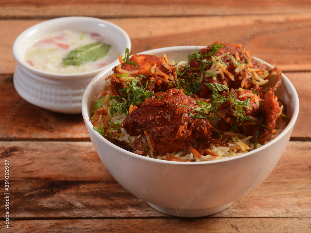 Boneless Chicken dum Biryani made of Basmati rice cooked with masala spices, served with Onion raita, selective focus Boneless Chicken dum Biryani made of Basmati rice cooked with masala spices, served with Onion raita, selective focus