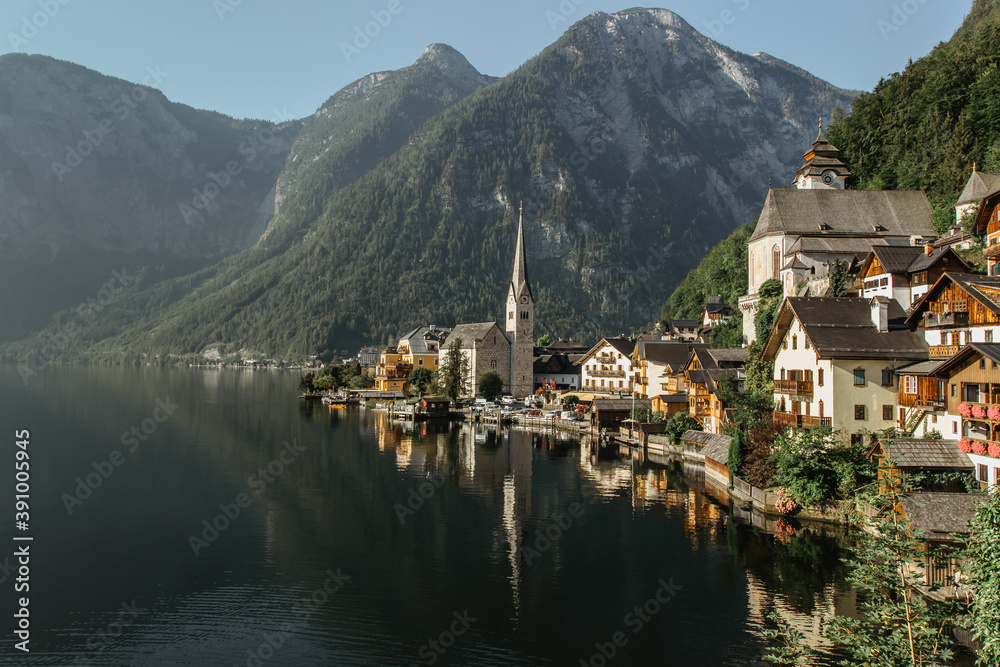 Classic postcard view of famous Hallstatt lakeside town, Austria. Scenic panoramic view of beautiful town reflecting in Hallstatter See.Beautiful sunny day in summer, Salzkammergut region.Urban scene.
