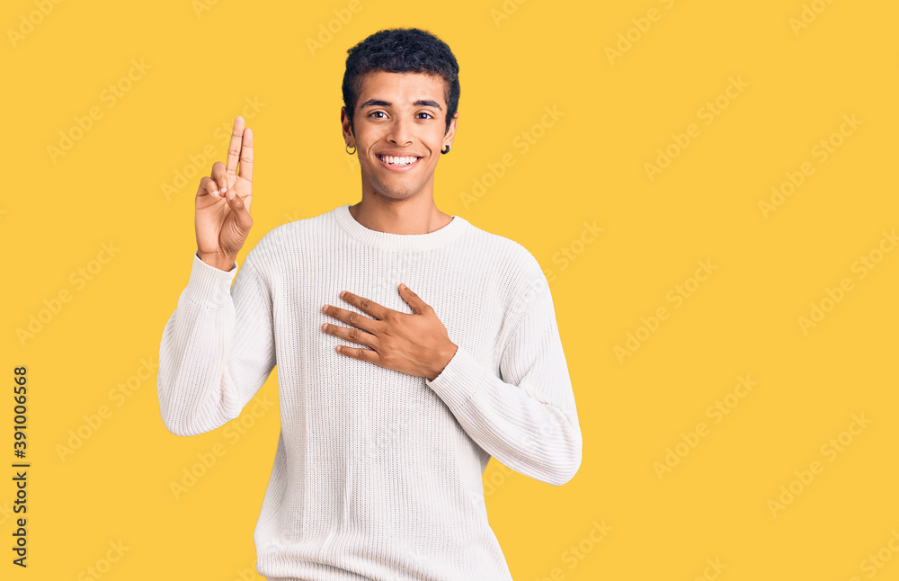 Young african amercian man wearing casual clothes smiling swearing with hand on chest and fingers up, making a loyalty promise oath Young african amercian man wearing casual clothes smiling swearing with hand on chest and fingers up, making a loyalty promise oath