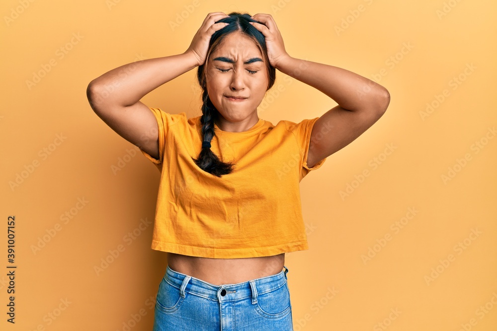 Young latin woman wearing casual clothes suffering from headache desperate and stressed because pain and migraine. hands on head.