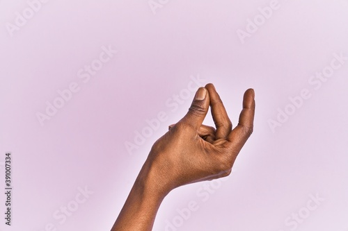 Arm and hand of black middle age woman over pink isolated background snapping fingers for success, easy and click symbol gesture with hand