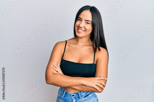 Young beautiful hispanic girl wearing casual clothes happy face smiling with crossed arms looking at the camera. positive person.