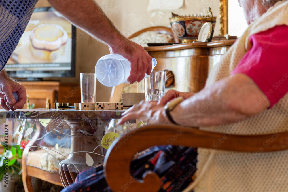 Naklejka premium Un aide à domicile hydrate une personne âgée