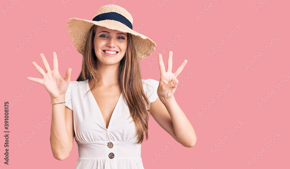 Young beautiful blonde woman wearing summer dress and hat showing and pointing up with fingers number eight while smiling confident and happy. Young beautiful blonde woman wearing summer dress and hat showing and pointing up with fingers number eight while smiling confident and happy.