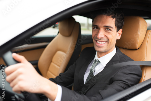 Smiling business man driving his new car © Minerva Studio