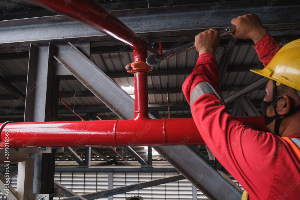 Install fire sprinkler system. In the industrial plant, pipe assembly, red fire pipe, fire protection contractors Using Scissor Lift High work - obrazy, fototapety, plakaty 