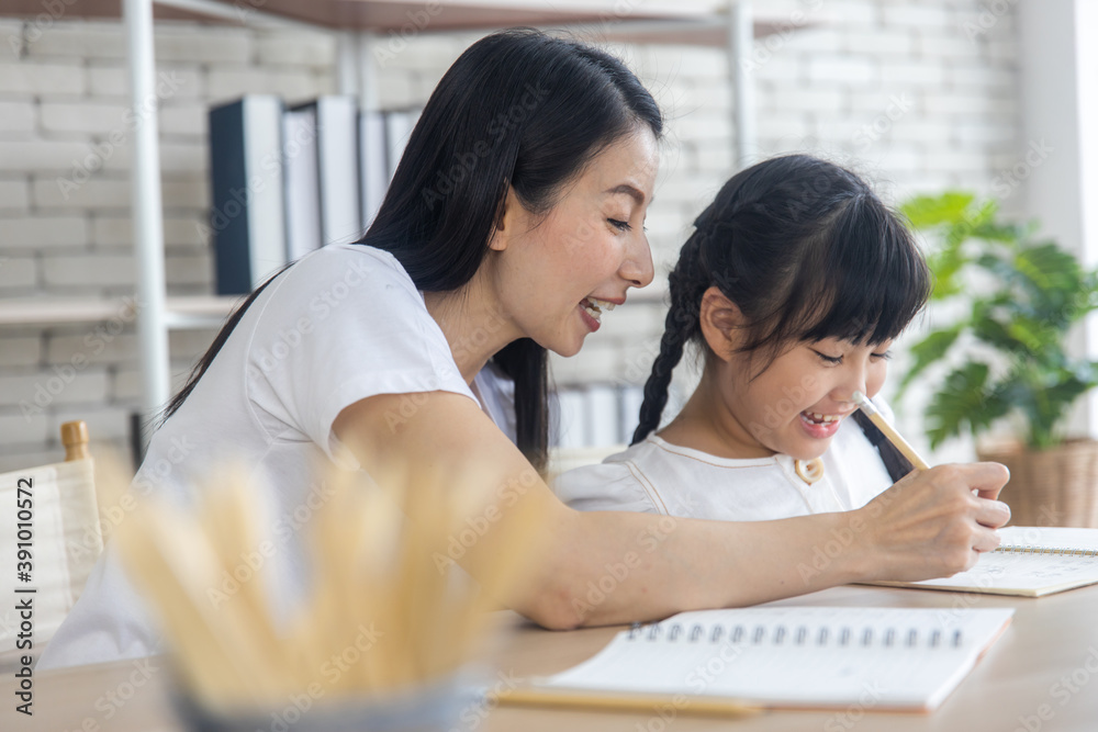 Obraz premium Asian mother, mom teach homework to daughter learning at home, happy family and education home school concept