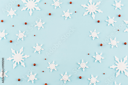 Christmas composition. Pattern made of snowflakes, red decorations on blue background. Christmas, winter, new year concept. Minimal style. Flat lay, top view.