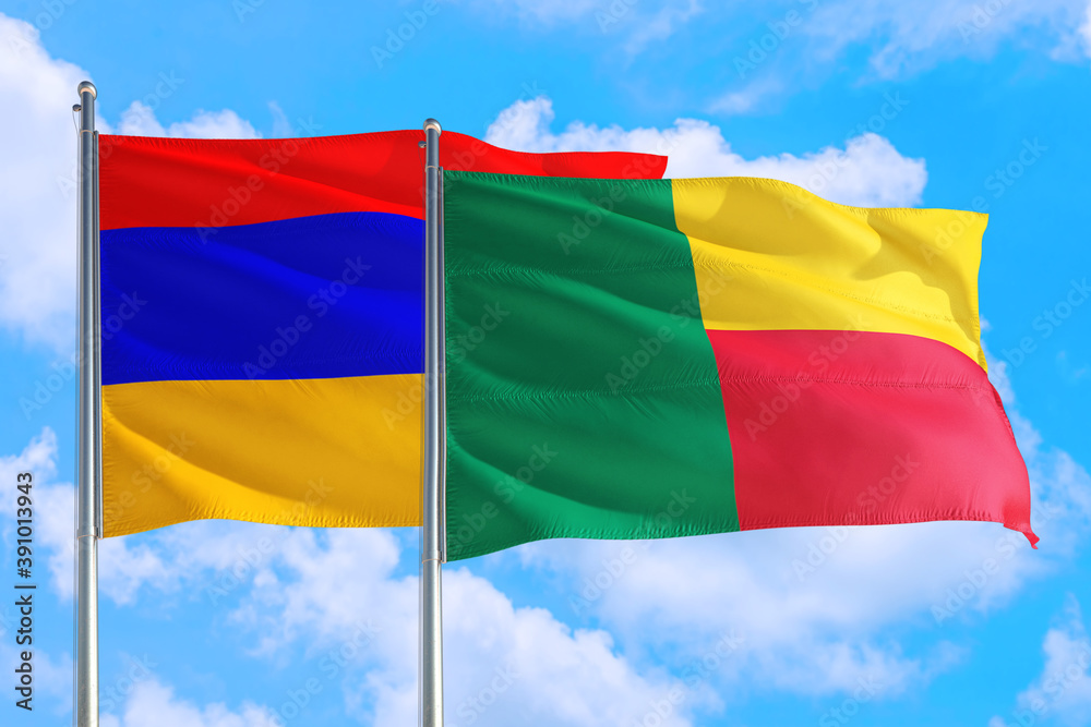 Fototapeta premium Benin and Armenia national flag waving in the windy deep blue sky. Diplomacy and international relations concept.