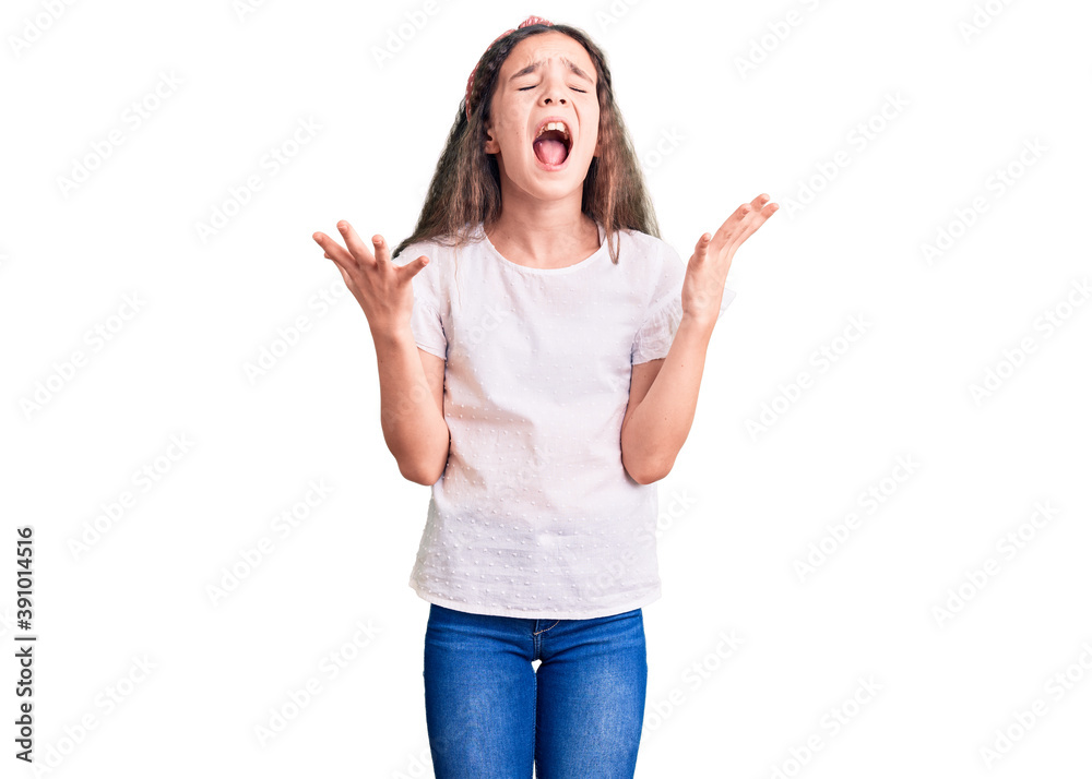 Cute hispanic child girl wearing casual white tshirt celebrating mad and crazy for success with arms raised and closed eyes screaming excited. winner concept Cute hispanic child girl wearing casual white tshirt celebrating mad and crazy for success with arms raised and closed eyes screaming excited. winner concept