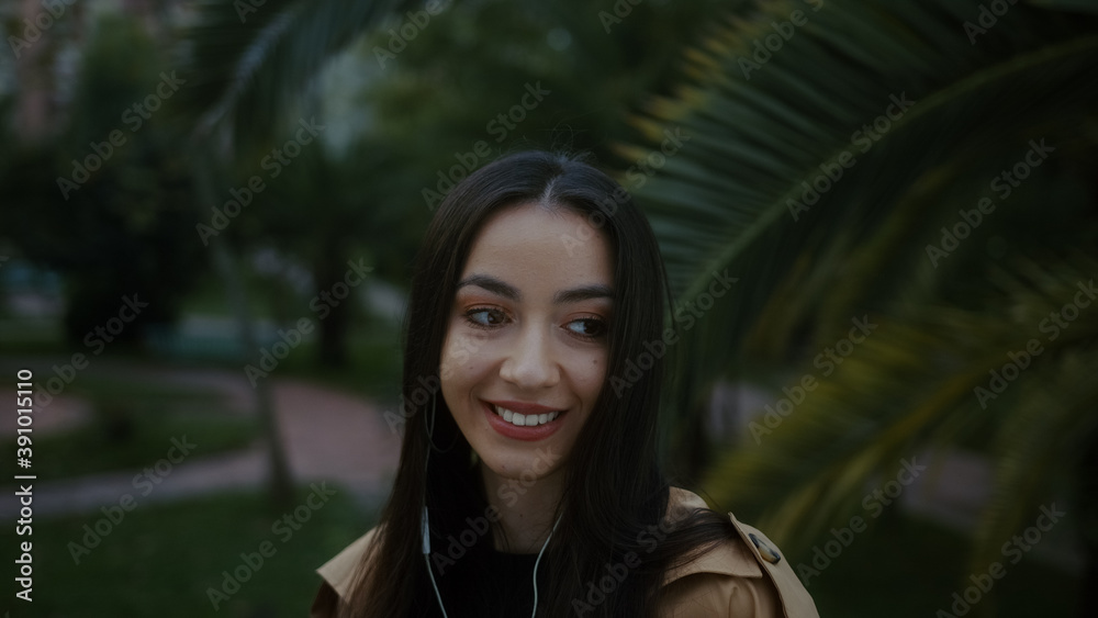 Pretty young smiling woman with her phone and headset listens to music and happily dances on foot, music dance and lifestyle concept Pretty young smiling woman with her phone and headset listens to music and happily dances on foot, music dance and lifestyle concept