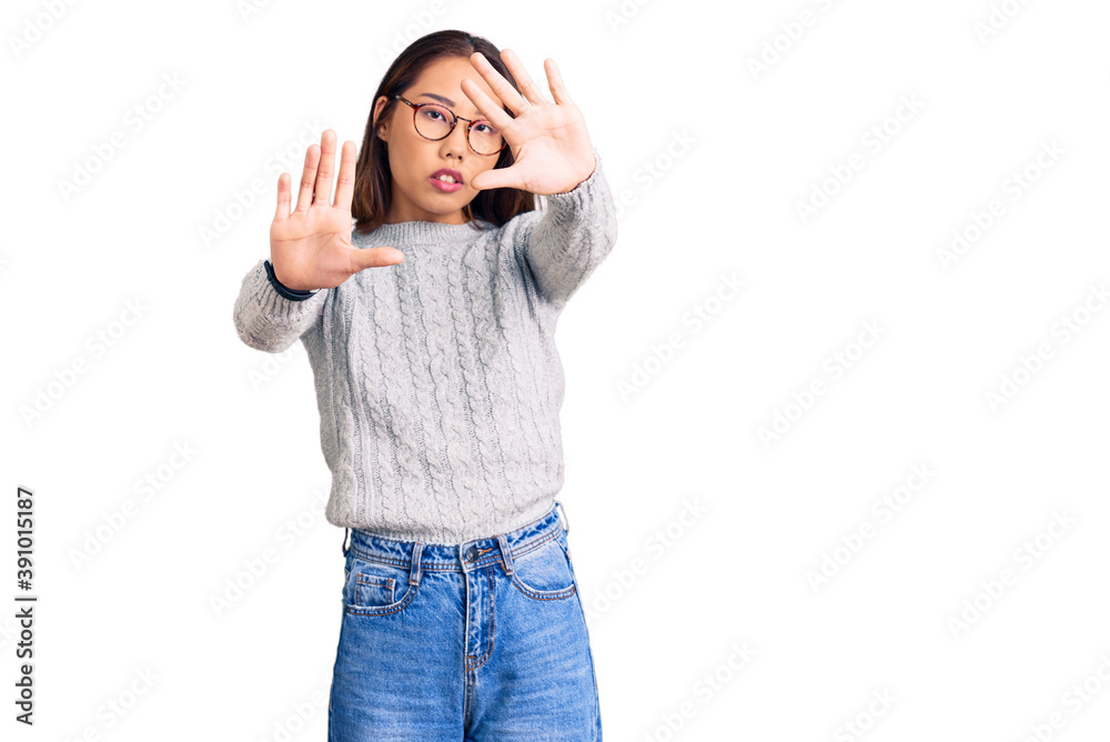 Young beautiful chinese girl wearing casual clothes doing frame using hands palms and fingers, camera perspective Young beautiful chinese girl wearing casual clothes doing frame using hands palms and fingers, camera perspective