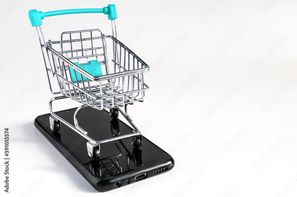 blue trolley at the supermarket, standing on the smartphone on a light background, the concept of online trading
