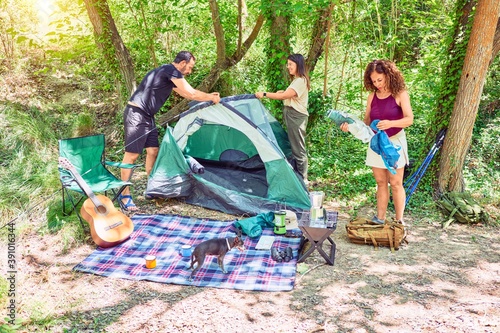 Fotografie Family of hiker setting up the tent to camping at the forest