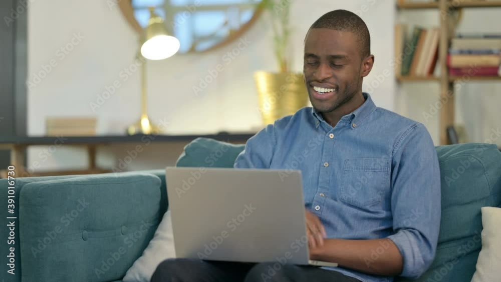 Online Video Call on Laptop by Young African Man on Sofa Online Video Call on Laptop by Young African Man on Sofa