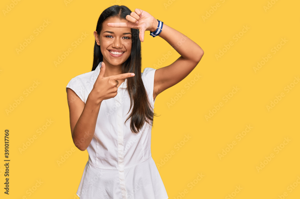 Beautiful hispanic woman wearing casual clothes smiling making frame with hands and fingers with happy face. creativity and photography concept. Beautiful hispanic woman wearing casual clothes smiling making frame with hands and fingers with happy face. creativity and photography concept.