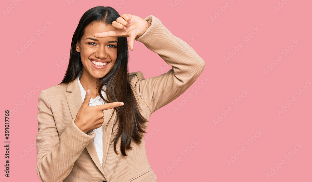 Beautiful hispanic woman wearing business jacket smiling making frame with hands and fingers with happy face. creativity and photography concept.
