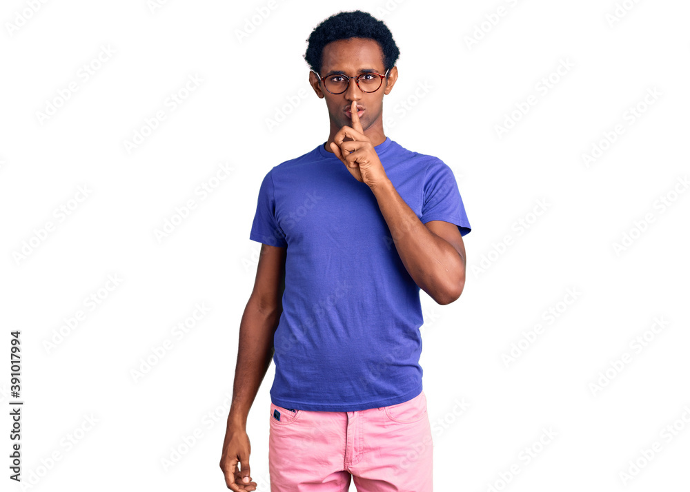 African handsome man wearing casual clothes and glasses asking to be quiet with finger on lips. silence and secret concept. African handsome man wearing casual clothes and glasses asking to be quiet with finger on lips. silence and secret concept.