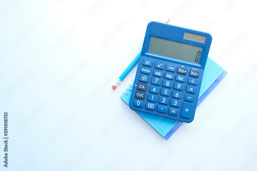 Close up of blue calculator and notepad on color background  - obrazy, fototapety, plakaty 