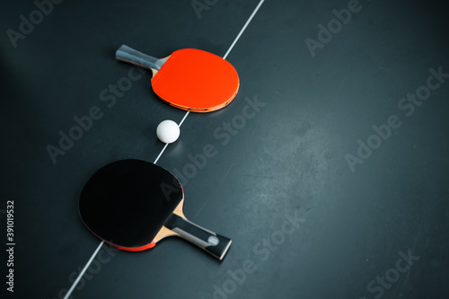 Ping pong ball and rackets on white line, top view