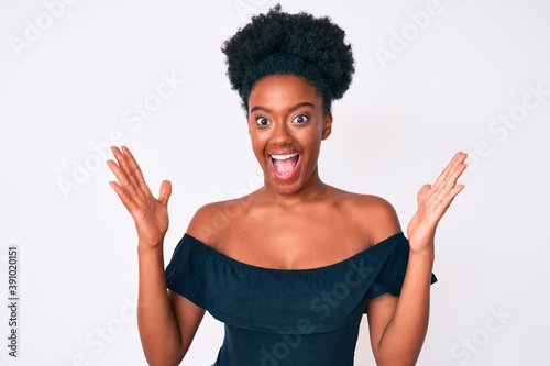 Young african american woman wearing casual clothes celebrating crazy and amazed for success with arms raised and open eyes screaming excited. winner concept