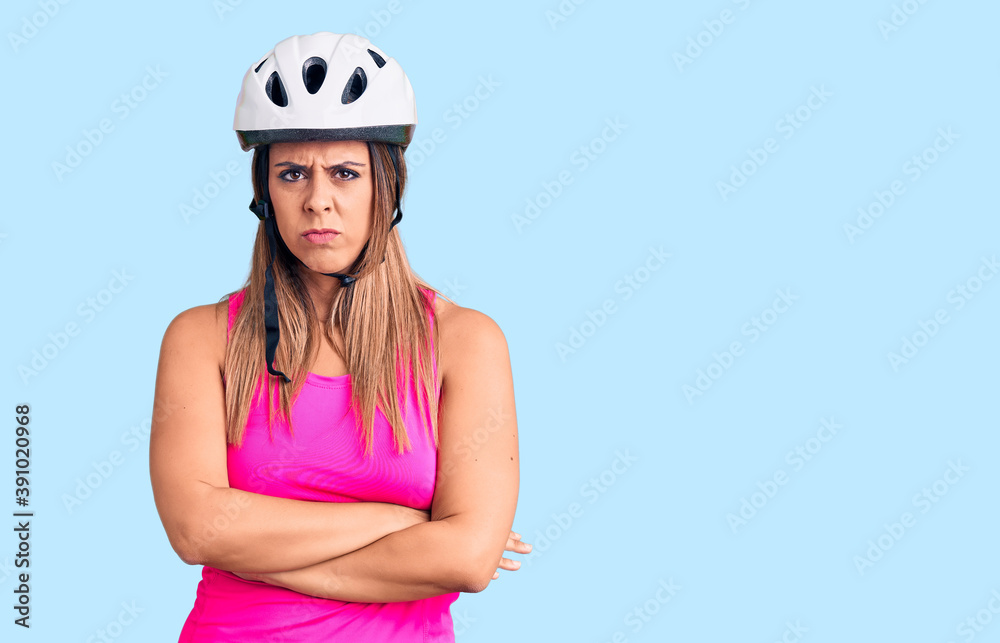 Young beautiful woman wearing bike helmet skeptic and nervous, disapproving expression on face with crossed arms. negative person. Young beautiful woman wearing bike helmet skeptic and nervous, disapproving expression on face with crossed arms. negative person.