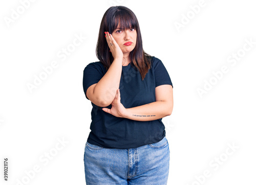 Young plus size woman wearing casual clothes thinking looking tired and bored with depression problems with crossed arms.