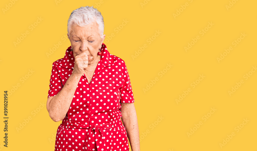 Senior beautiful woman with blue eyes and grey hair wearing a red summer dress feeling unwell and coughing as symptom for cold or bronchitis. health care concept. Senior beautiful woman with blue eyes and grey hair wearing a red summer dress feeling unwell and coughing as symptom for cold or bronchitis. health care concept.