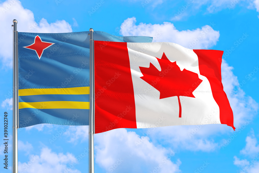 Canada and Aruba national flag waving in the windy deep blue sky. Diplomacy and international relations concept. Canada and Aruba national flag waving in the windy deep blue sky. Diplomacy and international relations concept.