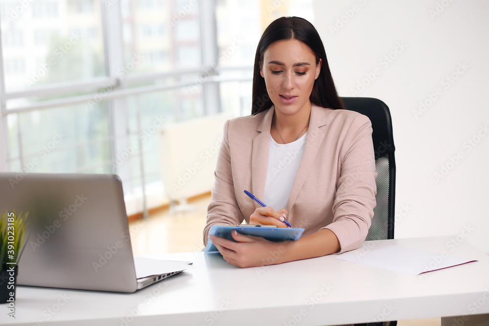 Obraz premium Young female content manager makes notes with a pen