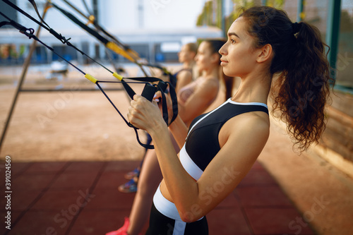Slim women doing exercise, outdoors group training