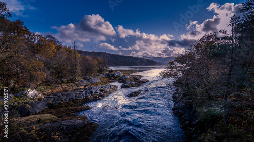 A river flowing into Loch Aline on the Ardtornish Estate in Scotland on a bright sunny day with dramatic clouds on an autumn day