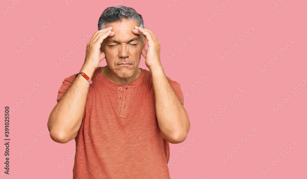 Handsome middle age man wearing casual clothes with hand on head for pain in head because stress. suffering migraine. Handsome middle age man wearing casual clothes with hand on head for pain in head because stress. suffering migraine.