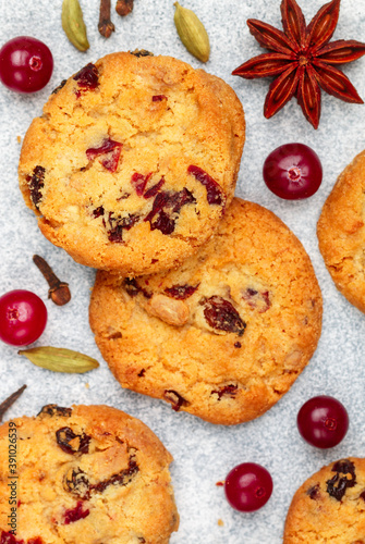 Freshly baked homemade cookies with cranberries, almonds, white chocolate and spices (cinnamon, cardamom, cloves, star anise) close-up. Oatmeal biscuits. Christmas, New year. Selective focus