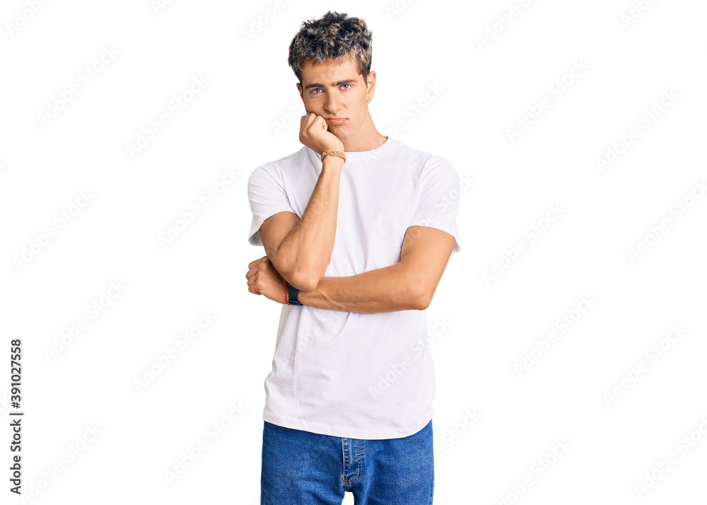 Young handsome man wearing casual white tshirt thinking looking tired and bored with depression problems with crossed arms. Young handsome man wearing casual white tshirt thinking looking tired and bored with depression problems with crossed arms.