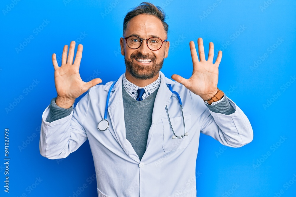 Handsome middle age man wearing doctor uniform and stethoscope showing and pointing up with fingers number ten while smiling confident and happy. Handsome middle age man wearing doctor uniform and stethoscope showing and pointing up with fingers number ten while smiling confident and happy.