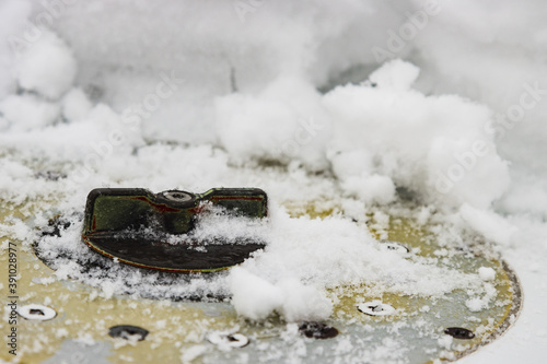 Fuel cap on the snow-covered wing of a small private plane, winter at the airfield.