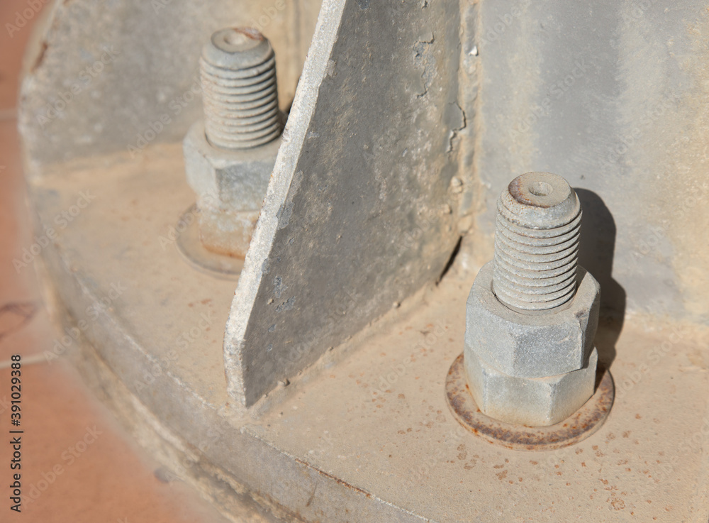 Closed up and selective focus short of grunge bolt and nut which were screwed at the base floor of electricity pole shows the beautiful details of rusty industrial equipment used outdoor Closed up and selective focus short of grunge bolt and nut which were screwed at the base floor of electricity pole shows the beautiful details of rusty industrial equipment used outdoor