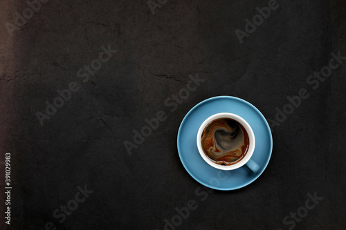 Blue coffee cup on dark grunge background top view 