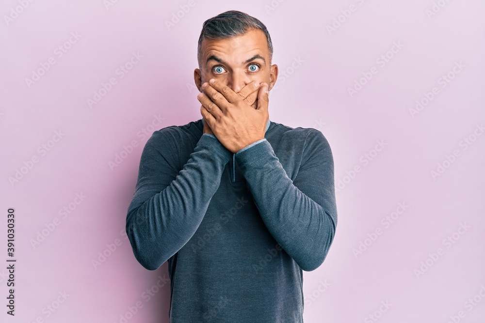 Middle age handsome man wearing casual clothes shocked covering mouth with hands for mistake. secret concept. Middle age handsome man wearing casual clothes shocked covering mouth with hands for mistake. secret concept.