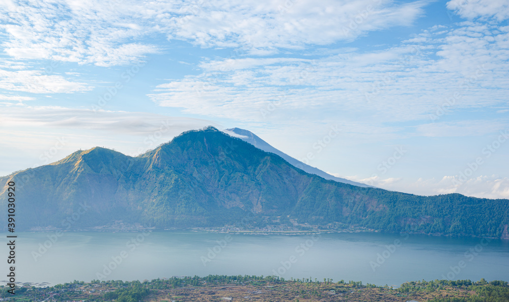 Panorama of popular trek destination Mount Batur eastern ridge at sunrise, with Danau Batur crater lake in Bali, Indonesia